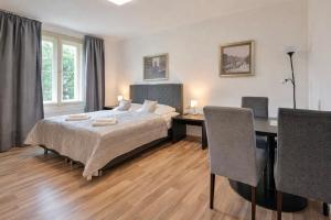 a bedroom with a bed and a desk and a table at Rabie Aparthotel in Prague