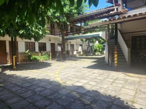 a courtyard of a building with a tree at Solemar in Guarapari +4 photos