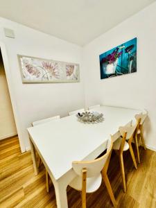 a white dining room with a white table and chairs at Céntrico Apartamento en Benidorm in Benidorm +9 photos
