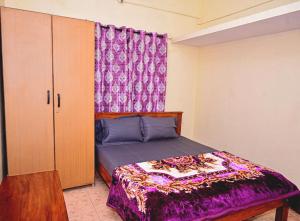 a bedroom with a bed with a purple comforter at coorg mantion homestay in Madikeri