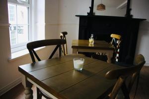 a wooden table with a glass of milk on top of it at Central Bar Guesthouse in Cushendall