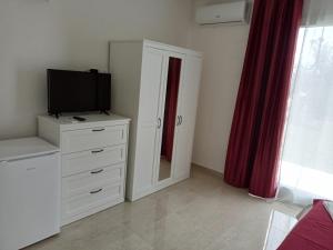 a bedroom with a dresser with a tv and a mirror at Villa Bello camere in Giurdignano