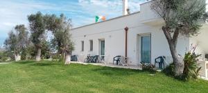a white building with a green door and a yard at Villa Bello camere in Giurdignano