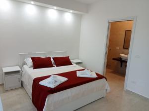 a white bedroom with a bed with towels on it at Villa Bello camere in Giurdignano