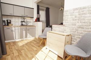 a kitchen with two chairs and a table and a brick wall at Ferienhus Baabe Ferienwohnung 01 mit gratis Nutzung vom AHOI Erlebnisbad und Sauna in Sellin in Baabe
