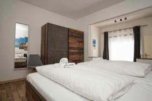 a bedroom with a large white bed and a window at Ferienhus Baabe Ferienwohnung 01 mit gratis Nutzung vom AHOI Erlebnisbad und Sauna in Sellin in Baabe +24 photos