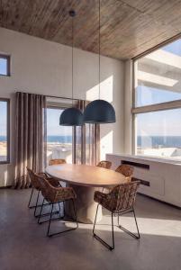 a dining room with a table and chairs and windows at Anzo Villas in Oia