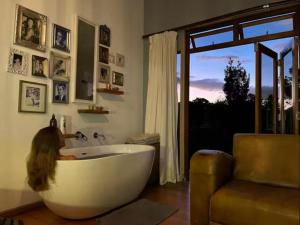 a woman sitting in a bath tub in a bathroom at River Star Retreat in Zuurbraak +34 photos