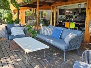 a patio with two blue couches and a table at River Star Retreat in Zuurbraak