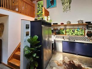 a kitchen with a stainless steel refrigerator and blue cabinets at River Star Retreat in Zuurbraak