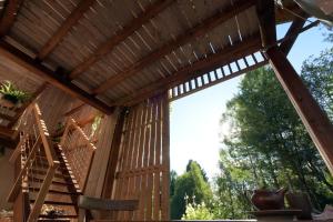 a view from inside a wooden pergola with a wooden stairs at B&B Mas de Lagorae in Tesero