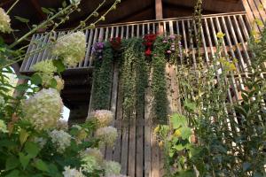 a balcony with flowers on a wooden fence at B&B Mas de Lagorae in Tesero