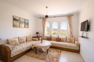 a living room with a couch and a table at Panoramic View, Cozy apartment M'diq in M'diq
