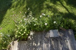 a garden with flowers and a wooden fence at B&B Mas de Lagorae in Tesero