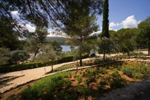 a park with trees and a lake in the background at Hotel Kimen - Annex in Cres