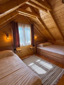 a bedroom with two beds in a wooden house at Cottage retreat- Skadar Lake in Virpazar