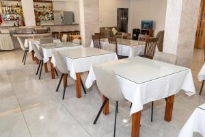 a dining room with white tables and chairs at Mariela Hotel Apartments in Polis Chrysochous