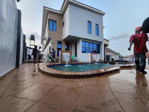 ein Haus mit einem Swimmingpool vor dem Haus in der Unterkunft The Bubbles Hotel in Akobo