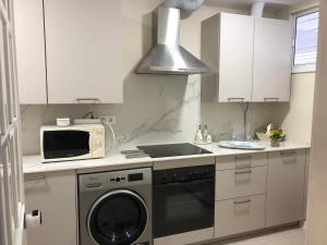 a kitchen with a washing machine and a microwave at Luxury Oceanfront triplex in Cadiz in Cádiz
