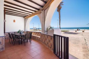 a patio with a table and chairs and the beach at Matalascañas Primera Línea de Playa in Matalascañas