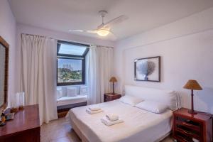 a bedroom with a white bed and a window at Magnolia bliss Calm & Cozy Villa, Sani in Sani Beach