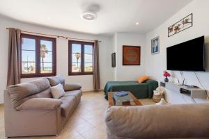 a living room with two couches and a flat screen tv at Matalascañas Primera Línea de Playa in Matalascañas