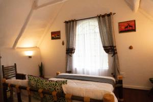 a bedroom with two beds in front of a window at Kitunduni Lodge in Arusha +93 photos