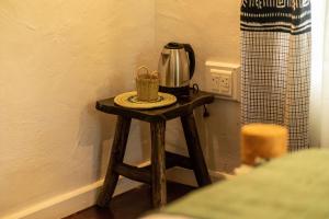 a small wooden table with a coffee maker on it at Kitunduni Lodge in Arusha