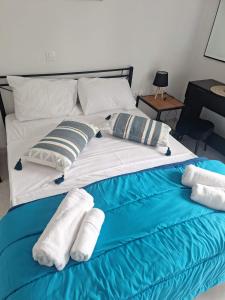 a large bed with towels and pillows on it at Glossy Messinian Escape - Cozy Yard Apartment in Filiatra