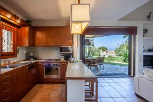 a kitchen with wooden cabinets and a view of a patio at Magnolia bliss Calm & Cozy Villa, Sani in Sani Beach +41 photos