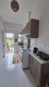 a kitchen with wooden cabinets and a counter top at Glossy Messinian Escape - Cozy Yard Apartment in Filiatra