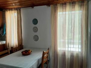 a table with a bowl of fruit on it with a window at ambelos view in Kotronas