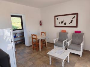 a living room with a table and two chairs and a table and a tablektop at Finca la Tabaiba piscina compartida adultos in Máguez