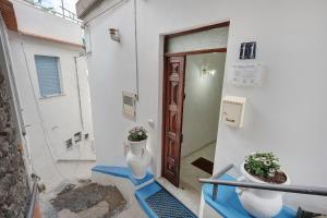 a door to a building with two vases on the steps at Le Terrazze Di Serafina in Furore +52 photos