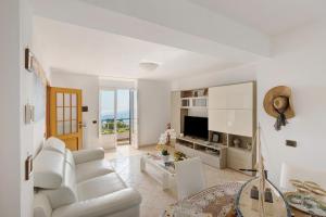 a living room with a white couch and a table at Le Terrazze Di Serafina in Furore