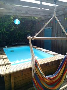a hammock in a backyard with a swimming pool at La Cabane Bordeaux St Augustin in Mérignac
