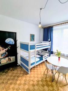 a bedroom with a bunk bed and a table at Luna Rooms Oświęcim in Oświęcim