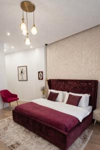 a bedroom with a large bed and a red chair at Hotel Capital Inn Tirana by Arta in Tirana +34 photos