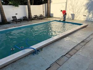a man is cleaning a pool with a hose at Arborea in Posadas