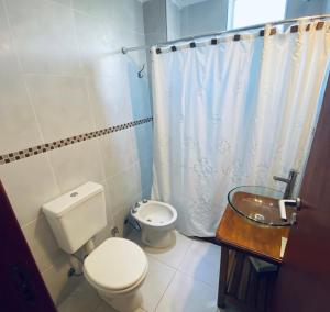 a white bathroom with a toilet and a sink at Arborea in Posadas +25 photos
