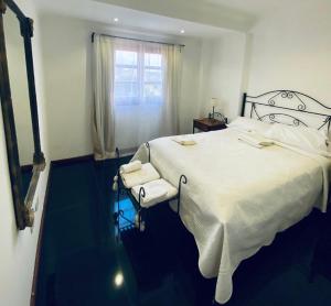 a bedroom with a large white bed and a window at Arborea in Posadas