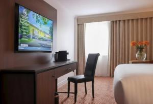 a hotel room with a bed and a desk with a television at Great National South Court Hotel in Limerick