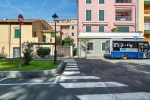 a blue bus driving down a street with buildings at Bilo Cinema in Bonassola