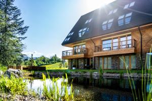 a house with a pond in front of it at Mountain Mood by Apart Concept Podhale in Kościelisko