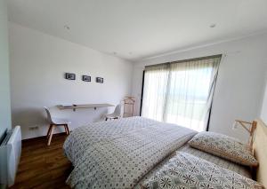 a bedroom with a bed and a desk and a window at Chambres d'hôtes La Ganivelle in Servant