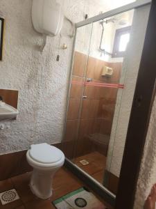 a bathroom with a toilet and a glass shower at Solemar in Guarapari