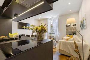 a kitchen with a counter and a living room at Piazzetta della Torre in Chiavari