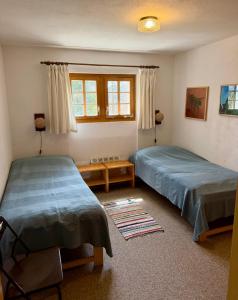 a bedroom with two beds and a window at Chalet Silentium in Bellwald
