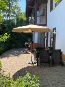 a table and chairs under an umbrella on a patio at Ferienwohnung Schwarzalb in Untere Mühlbauern