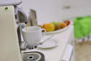 a cup of coffee with a bowl of fruit at VITALHOTEL Schulenberg in Schulenberg im Oberharz